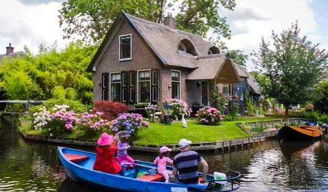 Günlük turda görülen Giethoorn kanalı boyunca sazdan çatılı çiftlik evleri