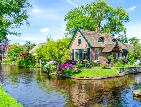 Paar steuert sein gemietetes Boot durch eine Gracht in Giethoorn